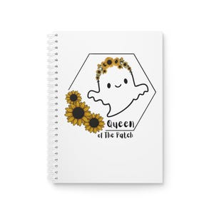 Könnte beinhalten: Ein weißes Spiralnotizbuch mit einer Grafik eines lächelnden Geistes, der einen Sonnenblumenkranz trägt, innerhalb eines schwarzen Sechsecks. Gelbe Sonnenblumen sind links angeordnet und der Text lautet Queen of The Patch in schwarzer Schrift.