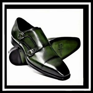Pode incluir: Um par de sapatos de couro verde-escuro com fivela dupla e acabamento polido. Os sapatos apresentam duas fivelas metálicas prateadas na lateral, bico quadrado e uma sola verde-escura com um logótipo da marca visível em relevo.