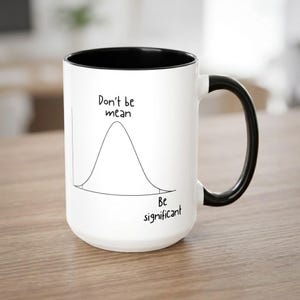 May include: A white ceramic mug with a black interior and handle. The exterior features a black line drawing of a bell curve graph. The text "Don't be mean" is printed above the curve, and "Be significant" is printed below the curve.