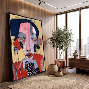 May include: A large framed vertical wall art piece featuring an abstract portrait of a person with dark blue hair, a pink face, and red lips. The figure wears a red garment with a black and white polka dot pattern, resting their chin on one hand.