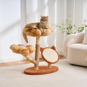 May include: A cat tree featuring a brown oval base, a central wooden post wrapped in sisal rope, and two plush, flower-shaped platforms in tan and brown. A circular scratching pad with cat-ear accents is attached to the side of the base.