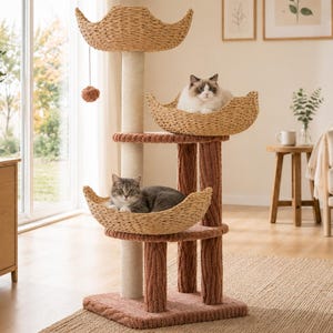 Op de afbeelding: Een kattenboom met meerdere niveaus, voorzien van drie gevlochten manden, een centrale krabpaal van sisal en twee bruine, getextureerde steunpilaren. Twee katten rusten in de manden en er is een kleine hangende speelbal bevestigd.