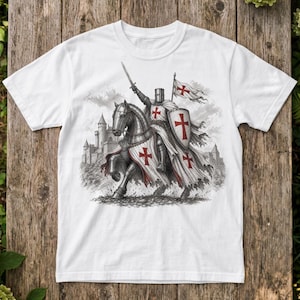 Może przedstawiać: Biały t-shirt ze szczegółową czarno-białą ilustracją graficzną przedstawiającą średniowiecznego rycerza w zbroi na koniu. Rycerz trzyma miecz i tarczę, obie ozdobione czerwonymi krzyżami, z zamkiem widocznym w tle.