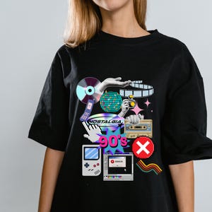 May include: A black t-shirt featuring a graphic print of 90s-themed icons including a CD, a flip phone, a disco ball, a camera, a cassette tape, a handheld game console, a computer error window, and the text "NOSTALGIA" and "90's".