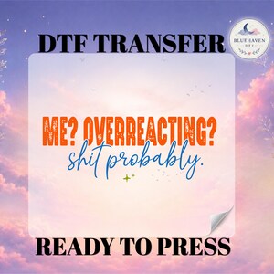 May include: A DTF transfer sheet featuring the orange text ME? OVERREACTING? and the blue cursive text shit probably. The design includes a small green star icon. The background is a soft purple and pink sky with a circular logo in the corner.