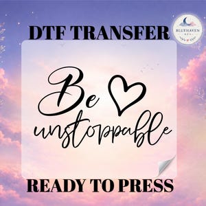 May include: A DTF transfer sheet featuring the black text Be unstoppable with a heart symbol. The design is set against a light purple and orange gradient background with floral outlines and a circular logo in the corner reading Bluehaven DTF.