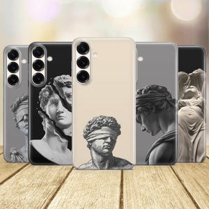 May include: Five smartphone cases arranged in a row, each featuring a different monochromatic classical sculpture illustration. The designs include a blindfolded figure, a fragmented bust, and various statues, all displayed on clear or solid-colored cases.