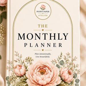Könnte beinhalten: Ein cremefarbener Hardcover-Planer mit einem goldfarbenen Bogenrahmen. Das Cover zeigt den Text "PEONY PAPER ATELIER", "THE MONTHLY PLANNER" und "Plan intentionally. Live beautifully." sowie eine große Illustration einer rosa Pfingstrose.