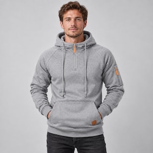 Puede incluir: Una sudadera con capucha de color gris jaspeado que presenta un cierre de cremallera de un cuarto con tirador naranja, capucha con cordones a juego, un bolsillo frontal tipo canguro y un pequeño bolsillo utilitario con cremallera.