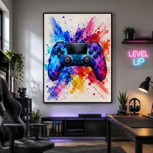 May include: A framed wall art print featuring a video game controller centred against a vibrant, multi-coloured watercolour splash background with shades of blue, purple, red, and yellow, displayed in a room with a neon Level Up sign.