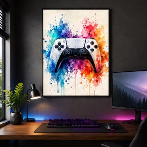 May include: A framed wall art print featuring a white video game controller centred against a vibrant watercolour splash background. The paint splatters transition from blue on the left to purple in the centre and orange on the right side.