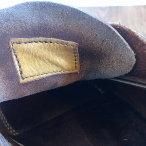 May include: The inside of a brown leather shoe with a yellow leather label sewn into the insole.