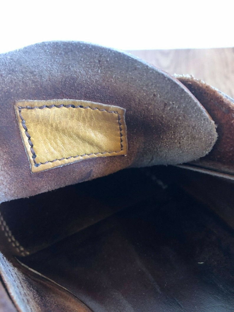 May include: The inside of a brown leather shoe with a yellow leather label sewn into the insole.