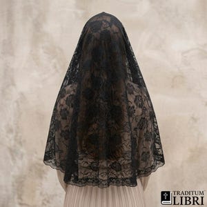 Peut inclure: Un voile de chapelle en dentelle noire orné d'un motif floral détaillé sur tout le tissu. Le voile présente un bord festonné le long de l'ourlet inférieur et est drapé sur la tête. Le logo TRADITUM LIBRI avec une croix est dans le coin.