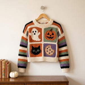 May include: A long-sleeve crochet sweater featuring a square-paneled design with a white ghost, an orange pumpkin, a black cat, and a chocolate chip cookie. The sleeves and trim are striped in cream, orange, green, purple, and black yarn colors.