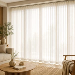 Puede incluir: Cortinas translúcidas de color blanco roto que van del suelo al techo con pliegues verticales que cubren un ventanal. La tela es traslúcida, permitiendo que pase una luz suave. Las cortinas cuelgan de un riel, creando pliegues uniformes.