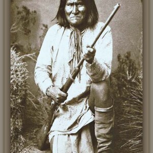May include: Sepia-toned photograph of a Native American man kneeling, holding a rifle. He wears a light-colored shirt, a scarf, and tall boots. The image has a vintage aesthetic, with the word "SAMPLE" faintly visible at the top.