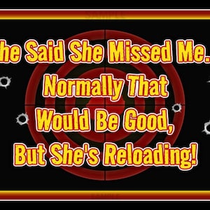 May include: A rectangular sign with a black background, a red and yellow bullseye, and bullet hole graphics. The text reads, "She Said She Missed Me... Normally That Would Be Good, But She's Reloading!" The sign has a gold border and a small "Made in USA" graphic.