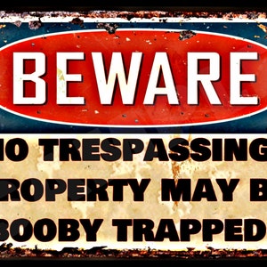May include: A rusty metal sign with a red circle and the word "BEWARE" in white letters. The sign reads "NO TRESPASSING! PROPERTY MAY BE BOOBY TRAPPED!"
