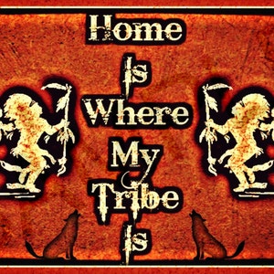 May include: A rustic-style sign with the text "Home is Where My Tribe Is." The design features two stylized figures, two howling wolves, and crescent moons. The background is a textured orange-red with a black border.
