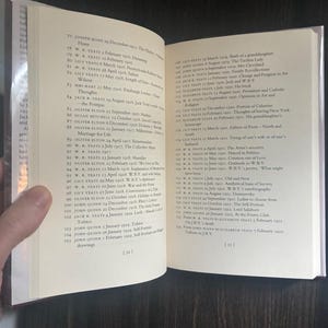 May include: An open book with cream-colored pages displaying a detailed index or list of entries. The text includes names like W.B. Yeats, Lily Yeats, and John Quinn, alongside specific dates and titles of various literary or historical topics.