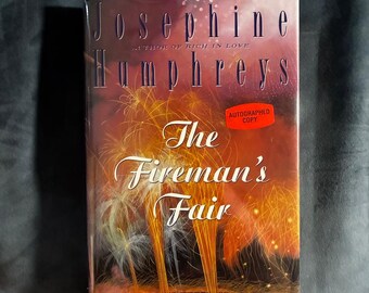 Può includere: Libro con copertina rigida intitolato The Fireman's Fair di Josephine Humphreys, autrice di Rich in Love. La copertina presenta uno sfondo scuro con strisce di luce arancioni e gialle simili a fuochi d'artificio e un adesivo rosso.