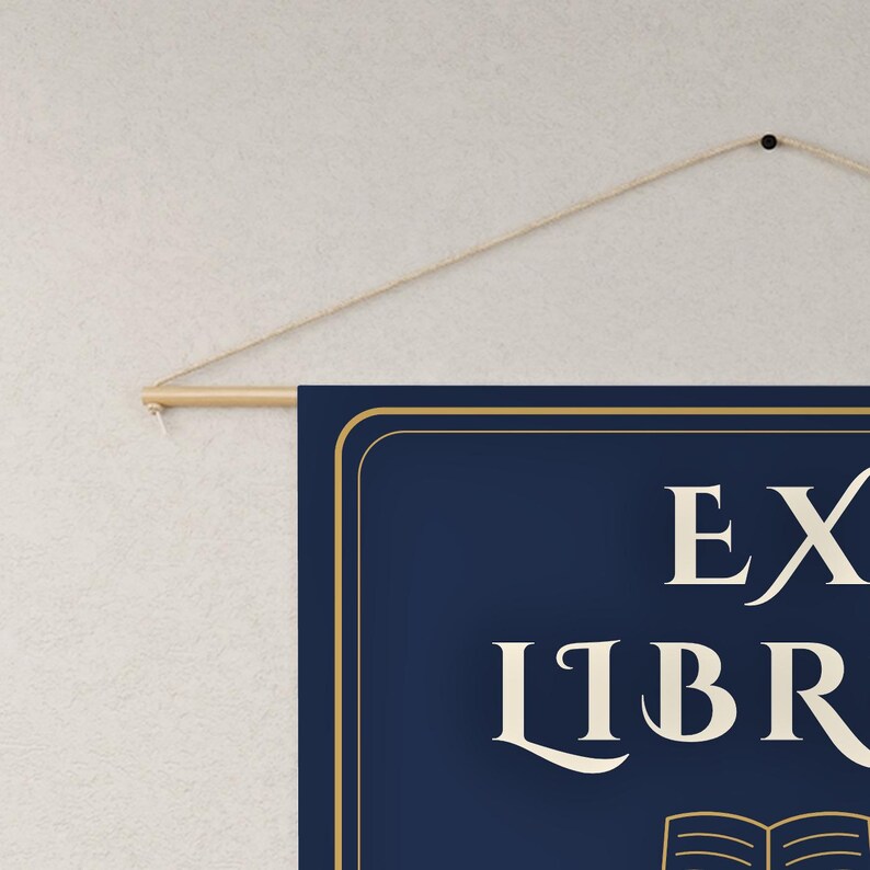 May include: A rectangular navy blue wall hanging banner featuring a gold border and the text EX LIBRIS in a cream-colored serif font. The banner is suspended from a light-colored wooden rod with a thin, natural-toned string attached for hanging.