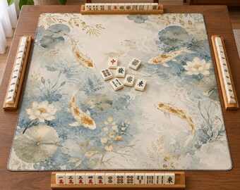 Può includere: Un tappetino da mahjong rettangolare con una stampa in stile acquerello raffigurante pesci koi dorati, fiori di loto bianchi e ninfee verdi su sfondo crema. Il tappetino è circondato da quattro supporti in legno con tessere color avorio.