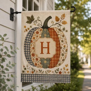 May include: A rectangular garden flag featuring a large central pumpkin illustration composed of various patterned segments including blue gingham, floral prints, and orange plaid. The letter H is centered in a cream-colored plaque on the pumpkin.
