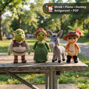 May include: Four crochet amigurumi dolls representing Shrek, Fiona, Donkey, and Puss in Boots. The figures feature detailed yarn textures, including Shrek's brown vest, Fiona's green dress, the grey donkey, and the orange cat with a hat and boots.