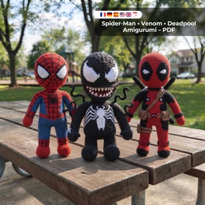 May include: Three crocheted dolls representing Spider-Man, Venom, and Deadpool. Spider-Man is red and blue with a web pattern. Venom is black with a white spider emblem and sharp teeth. Deadpool is red and black with a utility belt and swords.