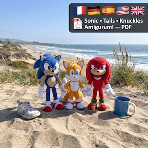 May include: Three crocheted amigurumi figures representing Sonic, Tails, and Knuckles. The blue, yellow, and red yarn characters stand on sand. A white sneaker and a blue mug are placed nearby. Text in the image reads: Sonic • Tails • Knuckles Amigurumi — PDF.