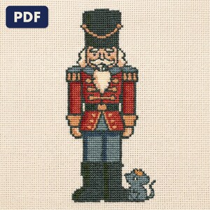 A finished a nutcracker and a mouse king cross stitch piece, stitched and framed on a wall