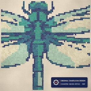Close up of the a dragonfly cross stitch design worked stitch by stitch, every cross and thread colour visible