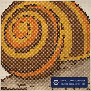 Close up of the a garden snail cross stitch design worked stitch by stitch, every cross and thread colour visible