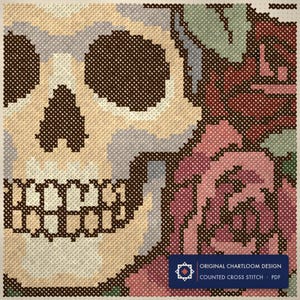 Close up of the skull wreathed in roses cross stitch design worked stitch by stitch, every cross and thread colour visible