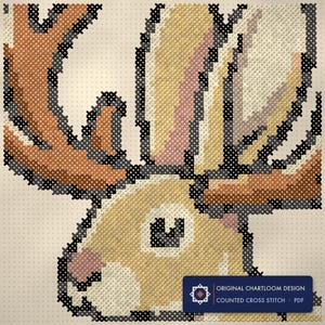 Close up of the jackalope cross stitch design worked stitch by stitch, every cross and thread colour visible