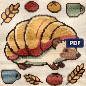 A finished hedgehog cross stitch piece, stitched and framed on a wall