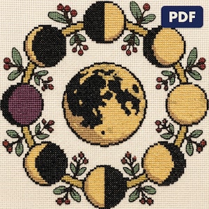 A finished a moon phase wheel cross stitch piece, stitched and framed on a wall