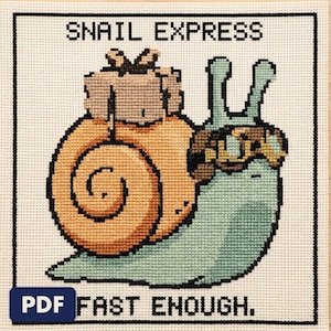 A finished snail express cross stitch piece, stitched and framed on a wall