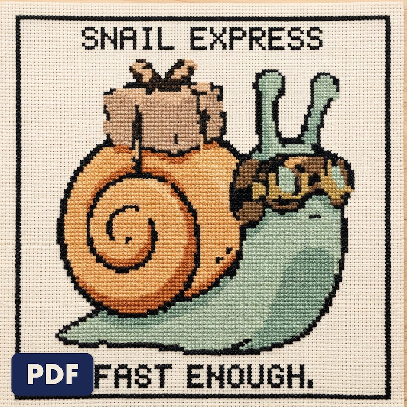 A finished snail express cross stitch piece, stitched and framed on a wall