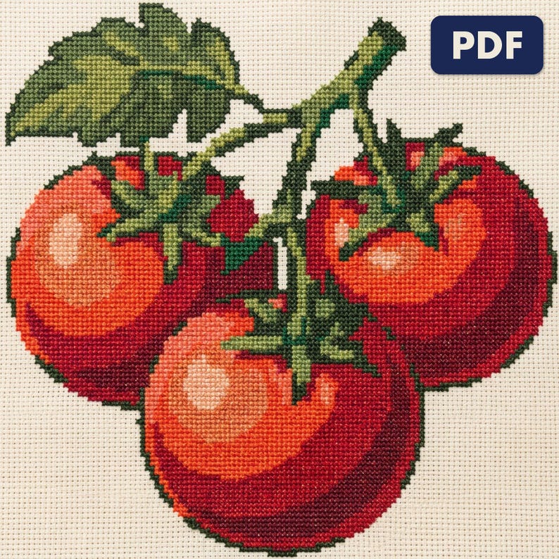 A finished vine tomatoes cross stitch piece, stitched and framed on a wall