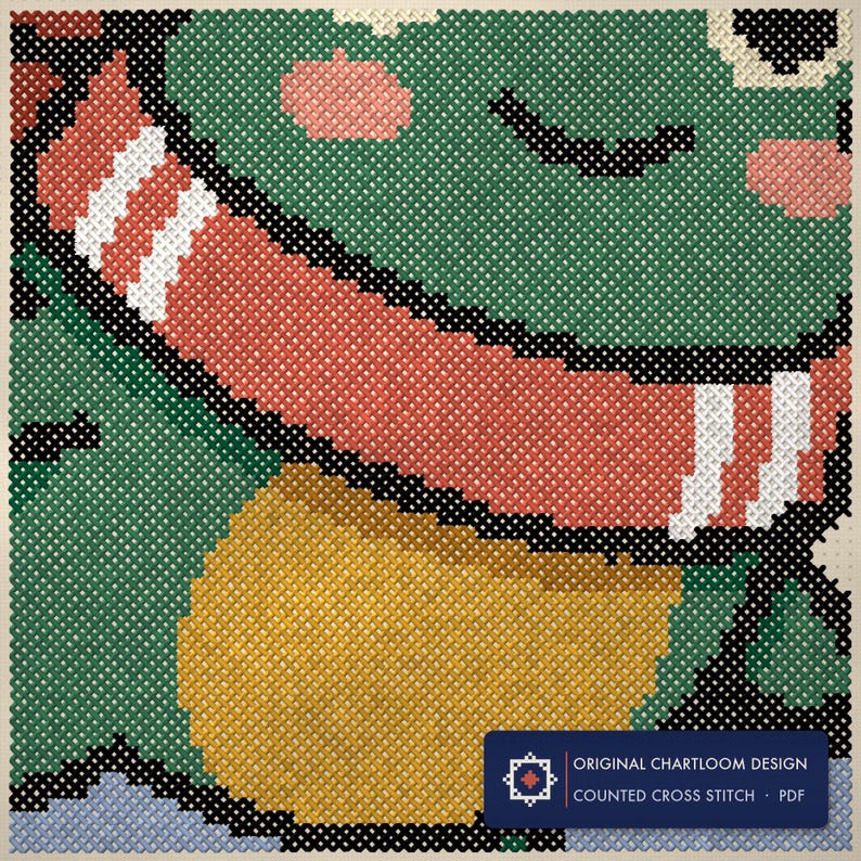Close up of the a frog ice skating cross stitch design worked stitch by stitch, every cross and thread colour visible