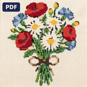 A finished a wildflower bouquet cross stitch piece, stitched and framed on a wall