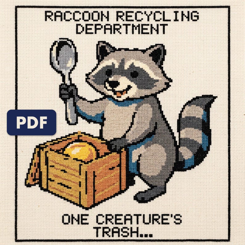 A finished raccoon recycling department cross stitch piece, stitched and framed on a wall