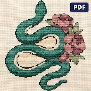 A finished serpent with roses cross stitch piece, stitched and framed on a wall