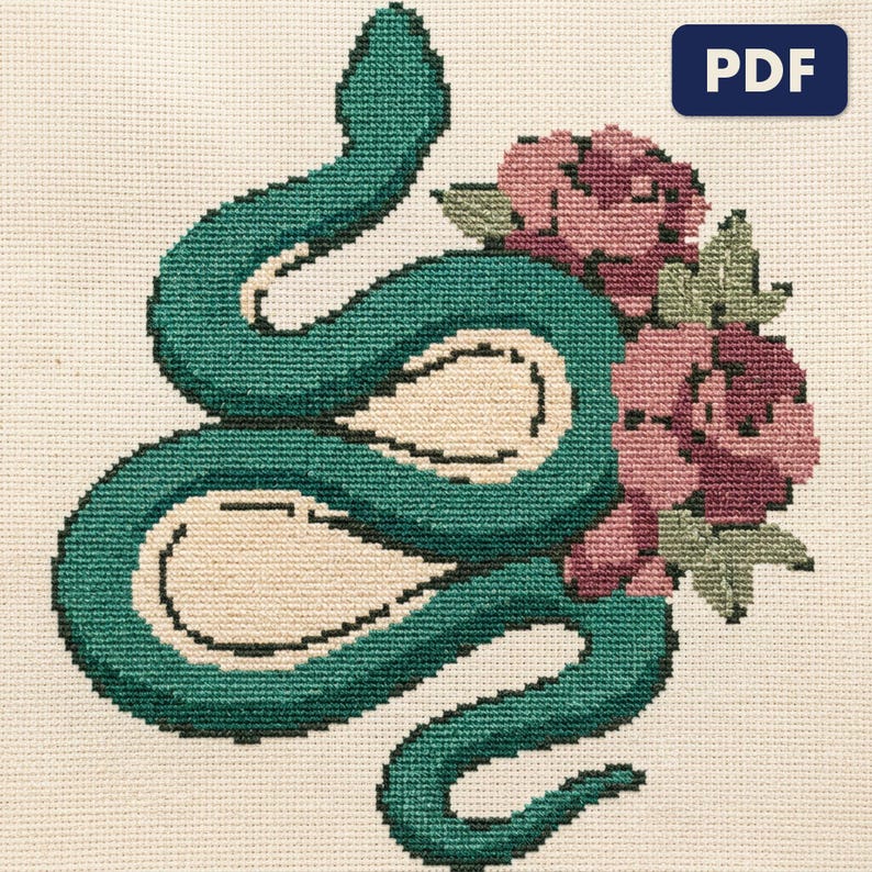 A finished serpent with roses cross stitch piece, stitched and framed on a wall