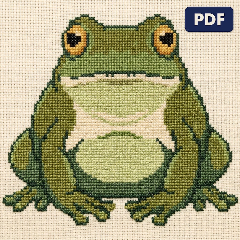 A finished a garden frog cross stitch piece, stitched and framed on a wall