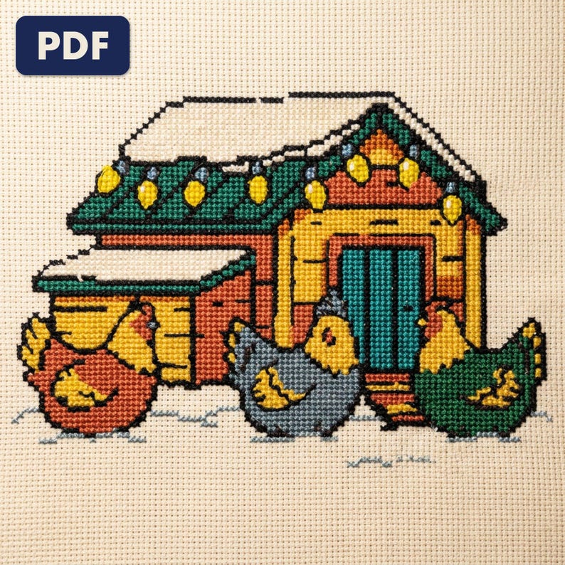 A finished hens before a winter coop cross stitch piece, stitched and framed on a wall