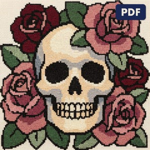 A finished skull wreathed in roses cross stitch piece, stitched and framed on a wall
